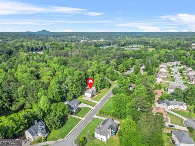 aerial view of property's location with a heavily wooded area and nearby suburban area