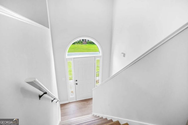 foyer with wood finished floors, stairs, and baseboards