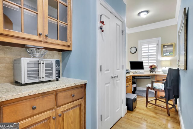 home office with ornamental molding and light wood-type flooring