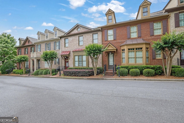 multi unit property with brick siding and a residential view