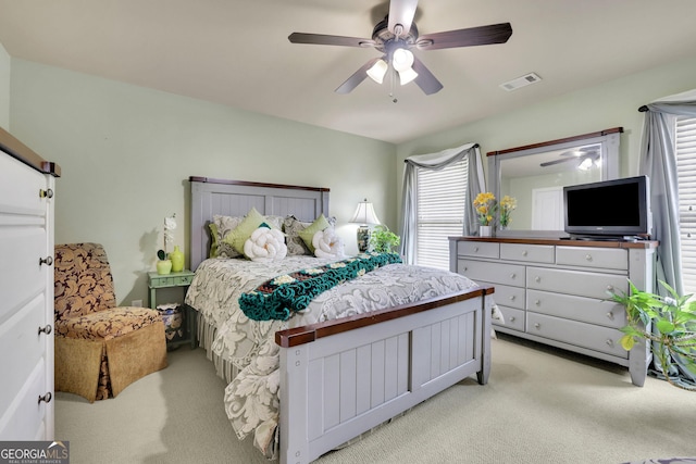 bedroom featuring light carpet and a ceiling fan