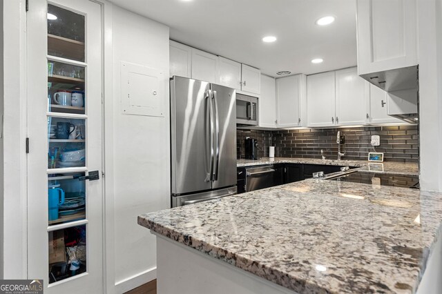 130 26th St NW Unit 801, Atlanta, GA 30309 - kitchen featuring appliances with stainless steel finishes, light stone countertops, white cabinetry, and recessed lighting