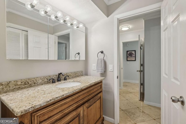 bathroom with crown molding, baseboards, and vanity