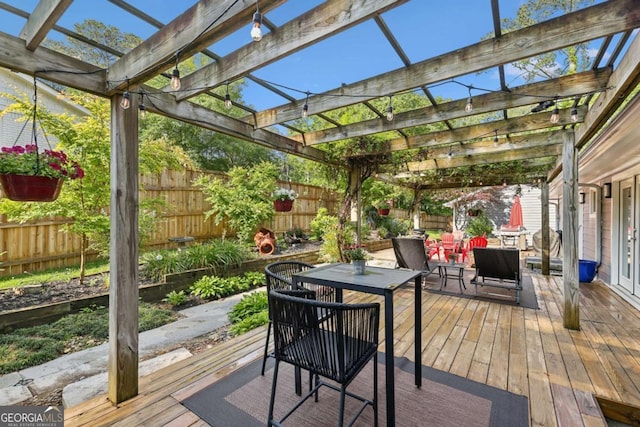 deck featuring a fenced backyard, a pergola, and outdoor dining space