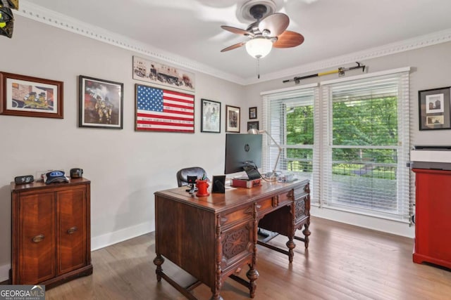 home office featuring ceiling fan, wood finished floors, ornamental molding, and baseboards