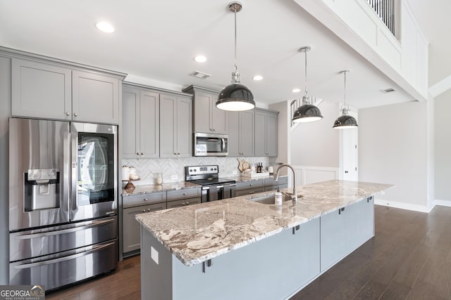 133 Wild Turkey Pass, Homer, GA 30547 - kitchen with stainless steel appliances, a sink, gray cabinets, a kitchen breakfast bar, and decorative backsplash