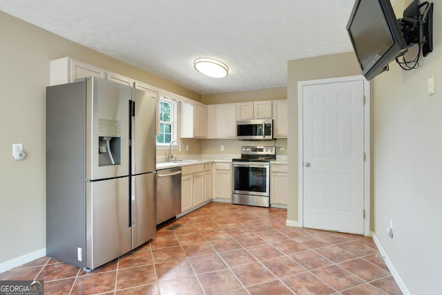 259 Pine Valley Dr, Powder Springs, GA 30127 - kitchen featuring appliances with stainless steel finishes, light countertops, light tile patterned floors, and a textured ceiling