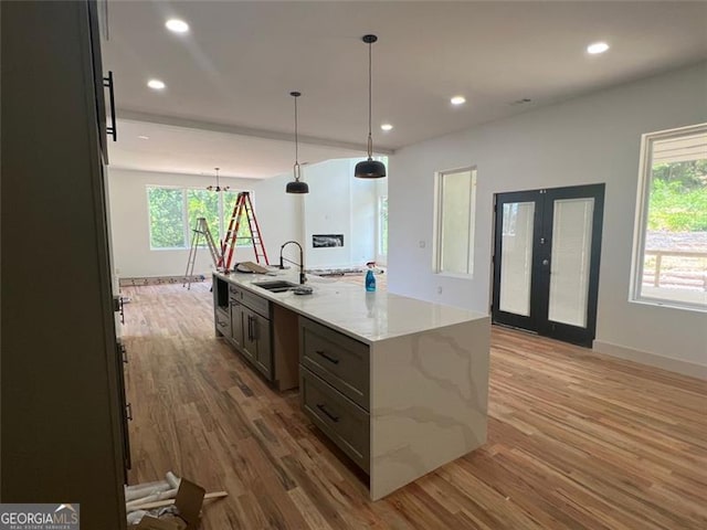 4107 Danforth, Atlanta, GA 30331 - kitchen with light wood-type flooring, a spacious island, recessed lighting, light stone countertops, and pendant lighting