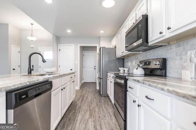 kitchen featuring appliances with stainless steel finishes, a sink, white cabinets, decorative backsplash, and recessed lighting