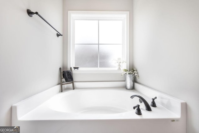 bathroom featuring plenty of natural light and a bath