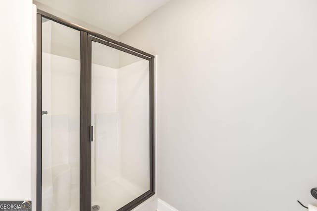 bathroom featuring a stall shower and baseboards