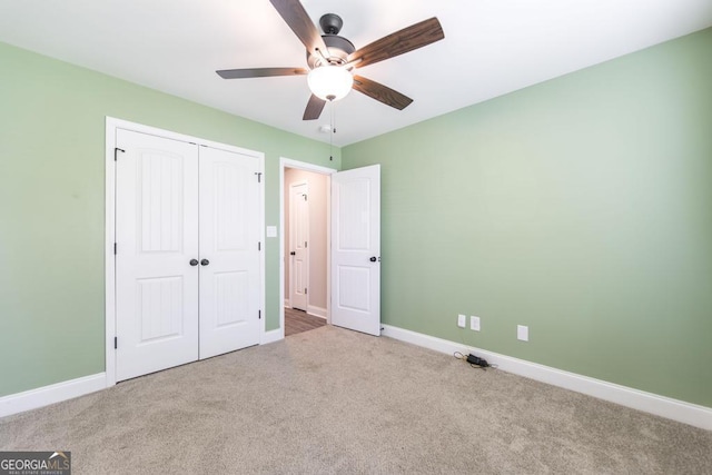 unfurnished bedroom featuring carpet flooring, baseboards, a closet, and a ceiling fan