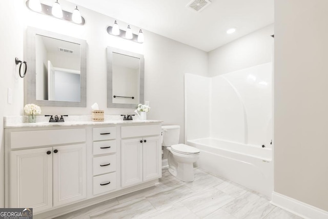 bathroom with toilet, double vanity, baseboards, marble look tiles, and shower / washtub combination