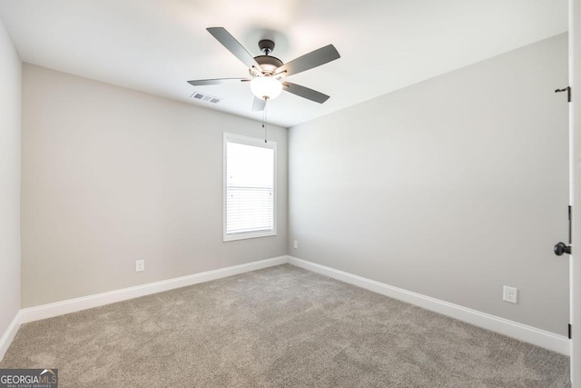 empty room featuring carpet floors, a ceiling fan, and baseboards