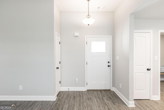 foyer featuring wood finished floors and baseboards