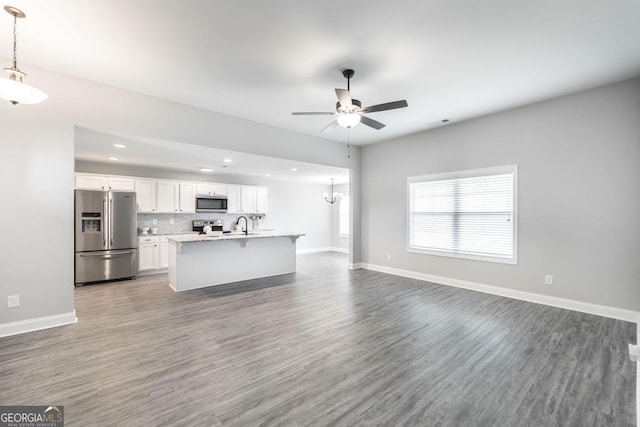 living area featuring a ceiling fan, wood finished floors, recessed lighting, baseboards, and a chandelier