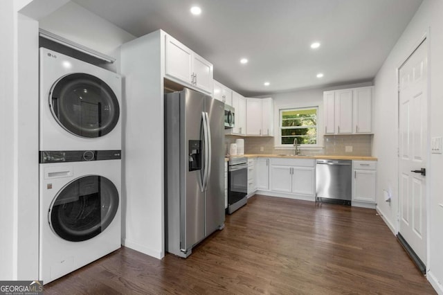 laundry room with stacked washer and clothes dryer, dark wood-style flooring, and recessed lighting