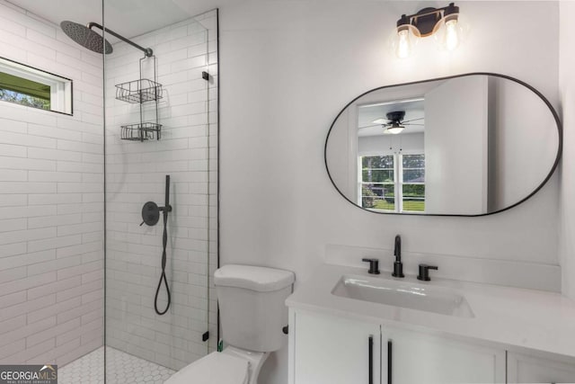 bathroom with healthy amount of natural light, tiled shower, and toilet