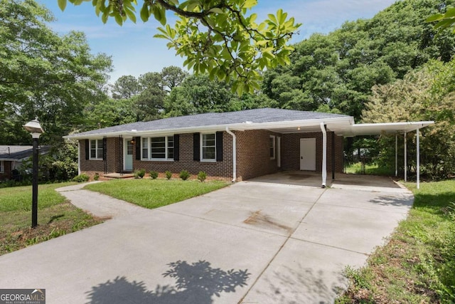 ranch-style home featuring concrete driveway, a front lawn, brick siding, and an attached carport