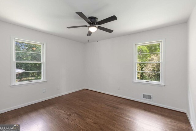 unfurnished room with dark wood-style flooring, baseboards, and ceiling fan