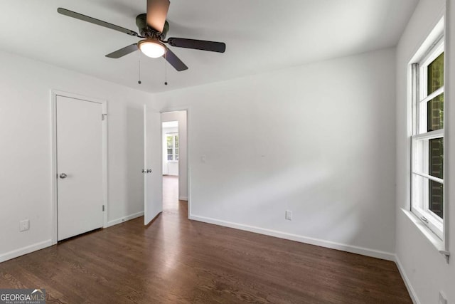 spare room with wood finished floors, ceiling fan, and baseboards