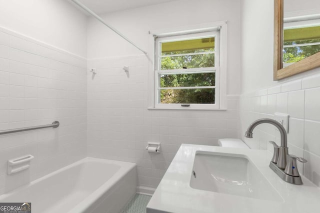 full bath featuring tile walls, shower / tub combination, toilet, and vanity