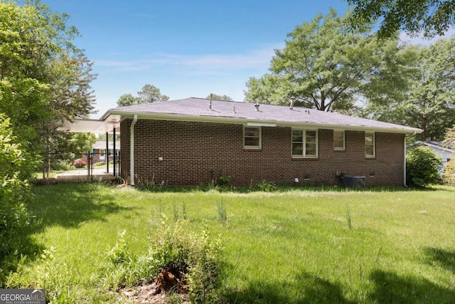back of property with a yard, brick siding, and cooling unit