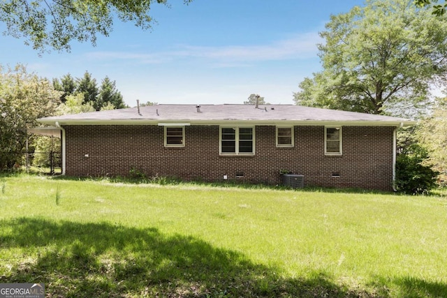 back of property featuring a yard, crawl space, and brick siding