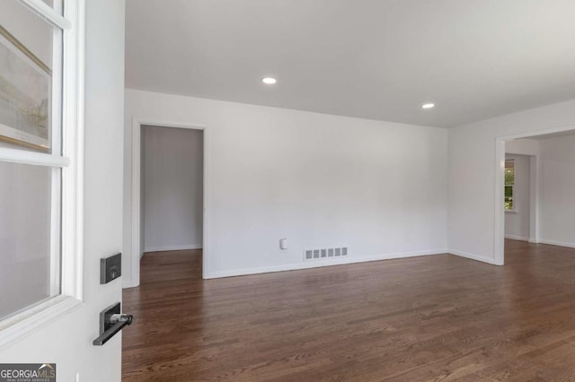 empty room featuring dark wood-style floors, baseboards, and recessed lighting