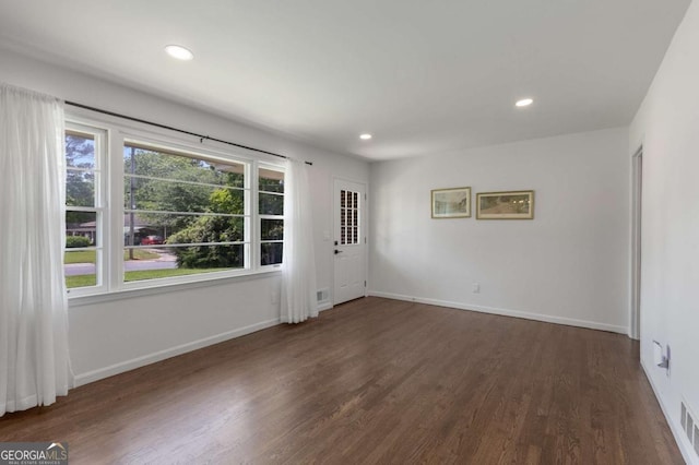 spare room featuring wood finished floors, recessed lighting, and baseboards