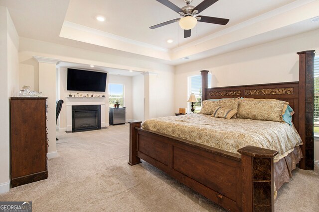 320 Conley Ave, Hampton, GA 30228 - bedroom featuring light carpet, a fireplace with flush hearth, ornamental molding, a tray ceiling, and ceiling fan