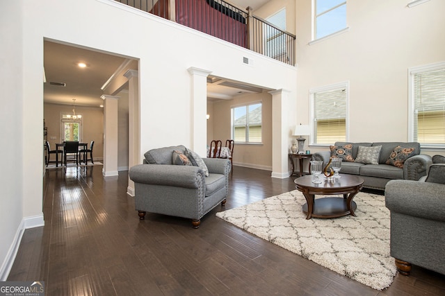 320 Conley Ave, Hampton, GA 30228 - living area with a chandelier, decorative columns, healthy amount of natural light, dark wood-style flooring, and a high ceiling