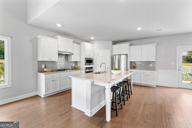 10 Georgian Oaks Ct, Newnan, GA 30265 - kitchen with appliances with stainless steel finishes, a sink, decorative backsplash, light wood-type flooring, and recessed lighting