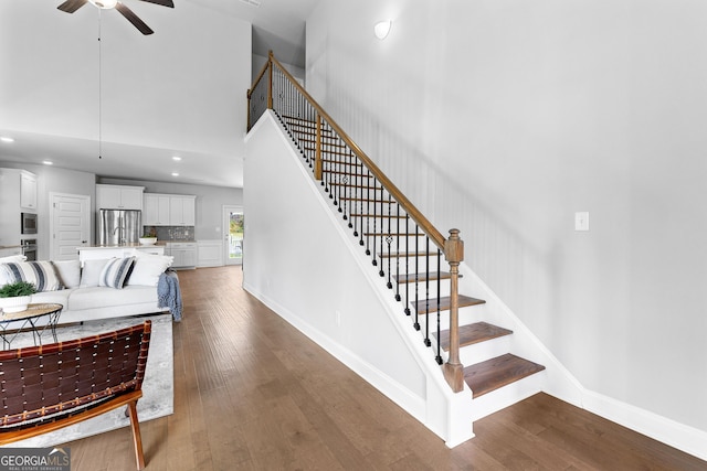 10 Georgian Oaks Ct, Newnan, GA 30265 - stairway featuring a ceiling fan, wood-type flooring, a towering ceiling, baseboards, and recessed lighting