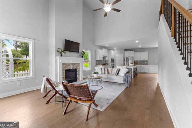 10 Georgian Oaks Ct, Newnan, GA 30265 - living room with a towering ceiling, stairs, a fireplace, baseboards, and a ceiling fan
