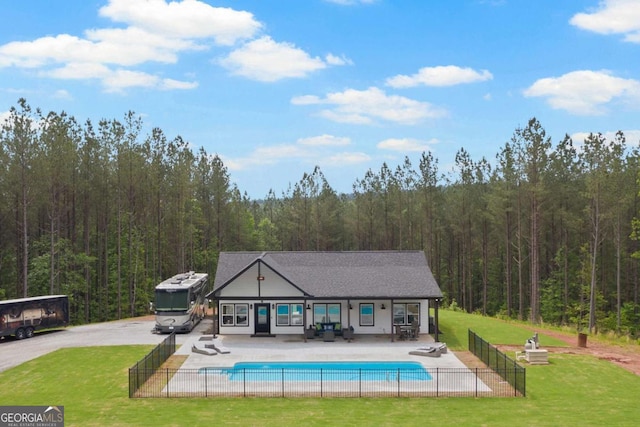 view of pool featuring a forest view and a patio