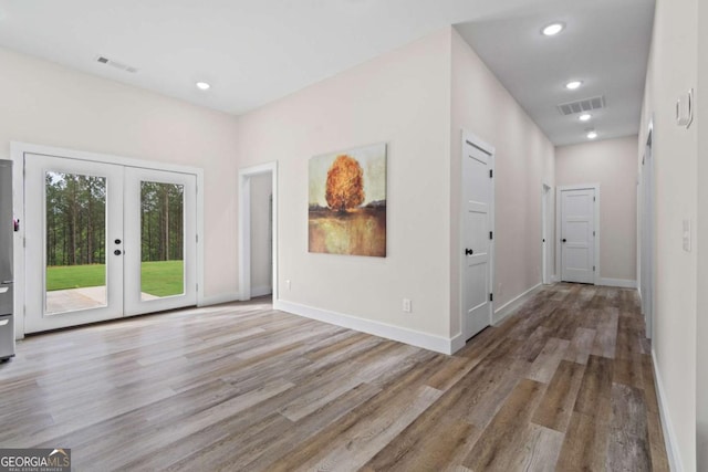 unfurnished room with wood finished floors, french doors, baseboards, and recessed lighting