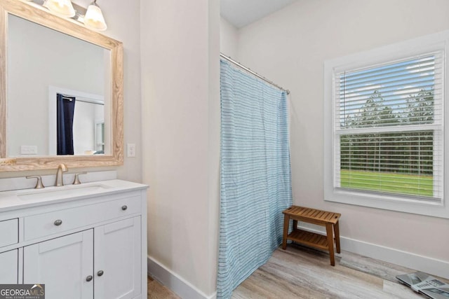 full bathroom with baseboards, wood finished floors, vanity, and a shower with curtain