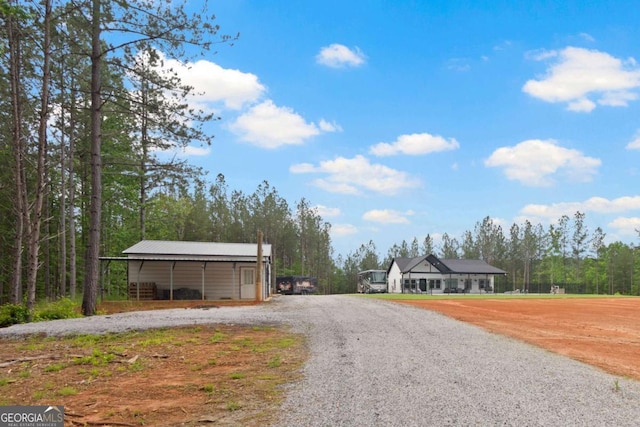 view of dirt / gravel road with an outbuilding