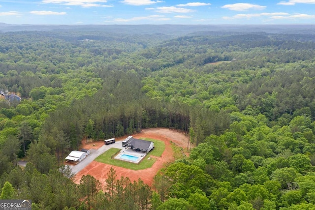 aerial view of a heavily wooded area and a pool