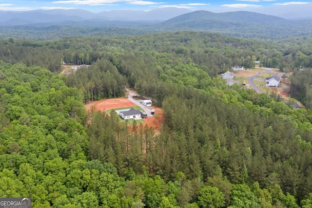 aerial view of a heavily wooded area and a mountainous background