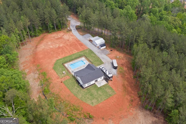 aerial overview of property's location with a forest and a pool area