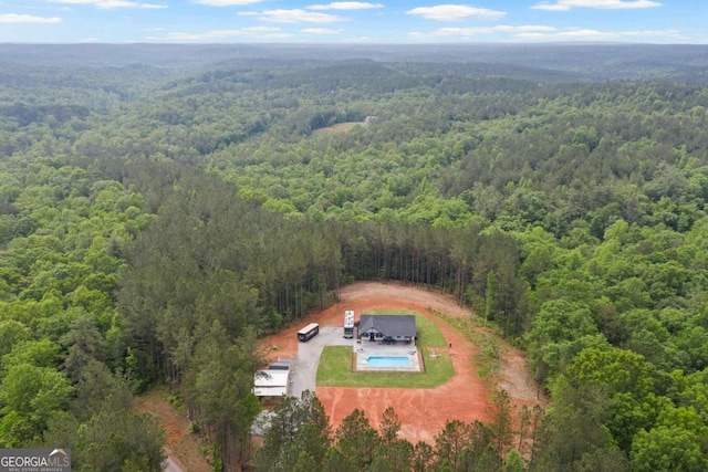 drone / aerial view of a forest and a pool area