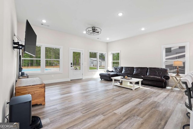living area featuring wood finished floors, healthy amount of natural light, recessed lighting, and baseboards