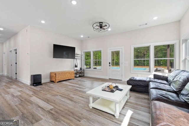 living room featuring recessed lighting, light wood-style floors, and baseboards