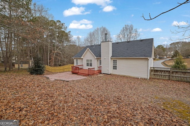 954 Josie Ct, Lawrenceville, GA 30045 - rear view of house with a deck, a fenced backyard, a chimney, and roof with shingles