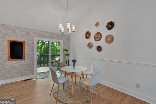 dining area with baseboards, a chandelier, wood finished floors, and lofted ceiling