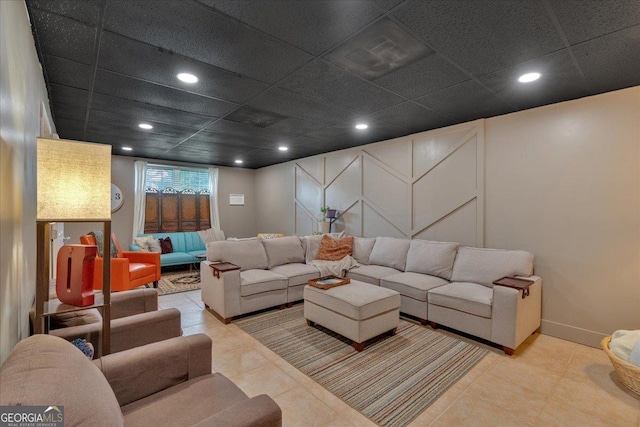 living area featuring tile patterned flooring, a decorative wall, and recessed lighting