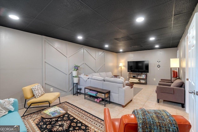 living area featuring recessed lighting, a decorative wall, and light tile patterned floors