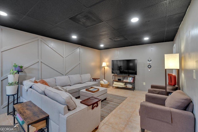 living area featuring a decorative wall, recessed lighting, and tile patterned floors